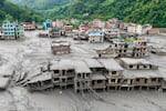 An aerial view shows houses lying deluged in sludge after flash floods at Devighat, Bidur Municipality in Nepal's Nuwakot district on August 27, 2026.