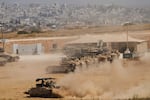 Israeli soldiers drive an armored vehicle at a staging area near the border with the Gaza Strip, in southern Israel, May 26.