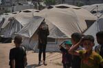 Displaced Palestinians wait for donated food at a community kitchen in Gaza City, northern Gaza Strip, Tuesday.