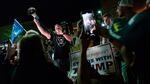 A man shouts into a bullhorn as Trump supporters gather in front of the Maricopa County Elections Department in Phoenix, where ballots were being counted following the 2020 presidential election. Federal officials have warned about violence erupting after this year's election, with experts particularly concerned about the period after Nov. 8.
