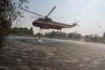 A firefighting helicopter refills water from a pond west of Friend, Ore., as crews battle the Grasshopper Fire, seen during a tour of the wildfire on Aug 3, 2026.