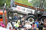 A flatbed truck rides by as a crowd rallies at the Capitol in Salem to protest House Bill 2020.