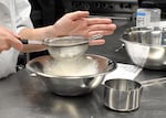 A student sifts flour for tres leches cake. Students in David Douglas High School’s culinary arts program create a menu weekly for The Kilt Eatery, a restaurant in the school that serves students and staff. Students had to make five cakes to feed 60 people.