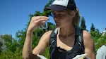 A volunteer holds up a butterfly.