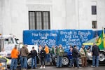 People stand in front of thea huge sign in support of Republican Senators who have been absent the past week at the Capitol in Salem. Hundreds rallied to protest the House Bill 2020.