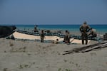Soldiers of the U.S. Army's 25th Infantry Division build fighting positions with sandbags along the beach of the La Paz sand dunes in Laoag City, Philippines.