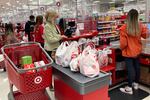 FILE - A customer wears a mask as she waits to get a receipt at a register in Target store in Vernon Hills, Ill., Sunday, May 23, 2021.  Retail sales rose modestly in March 2022, but higher prices for food, gasoline and other basics took a big share of their wallet. Retail sales increased 0.5% after registering a revised 0.8% jump from January to February.  (AP Photo/Nam Y. Huh, File)