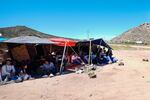 A group of people wait to be processed after crossing the border between Mexico and the United States as they seek asylum in April 2024, near Jacumba, Calif.