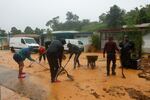 People clean debris from a road after a mudslide caused by Hurricane Fiona in Cayey, Puerto Rico.