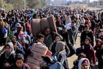 Palestinians carry some belongings as they flee Khan Younis to safer areas further south in southern Gaza, through the city's western exit, on the outskirts of its refugee camp, on Jan. 26.