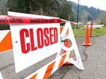 A sign and tape close off the entrance to Umpqua Wayside Park along the Umpqua River east of Reedsport