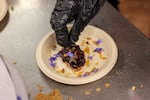 A student from Siletz Valley Schools’ culinary program adds the final touches to a cassava flour cracker dessert for Indigenous Food Summit attendees to try at Portland State University on Sept. 10, 2026.