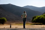 Amanda Smull looks at burned land neighboring her family's grazing lands near Durkee, Ore., July 31, 2024. "This is the first time I've been out here since it burned," she says. "It's hard to see."