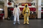 Emergency dispatchers in Portland will now try and ask callers about out-of-state travel, known exposure to the virus and any symptoms they may have. If the caller seems like they may have contracted COVID-19, firefighters might choose to wear either of the two protective suits, worn above by Kevin Leonard (left) and Bozeb Beckwith (right). 