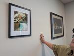 Mitchell looks at a photo of the main hatchery building burning during the wildfire, June 5, 2026.