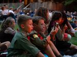 Two young novaky, male campers ages 6-11, look on in awe at the huge bonfire created every year for parents' weekend.