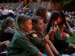 Two young novaky, male campers ages 6-11, look on in awe at the huge bonfire created every year for parents' weekend.