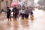 People walk through flooded streets in Valencia, Spain, on Wednesday, October 30, 2024. (AP Photo/Alberto Saiz)