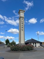 A blue sky with clouds with a clock tower that says Albany