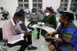 Five patients wait in a screening area for the COVID-19 vaccine shot.