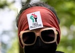 An attendee at a pro-Palestinian protest, with a sign reading "Free Palestine" on their head, on Portland State University's campus on April 29, 2024, in Portland, Ore.