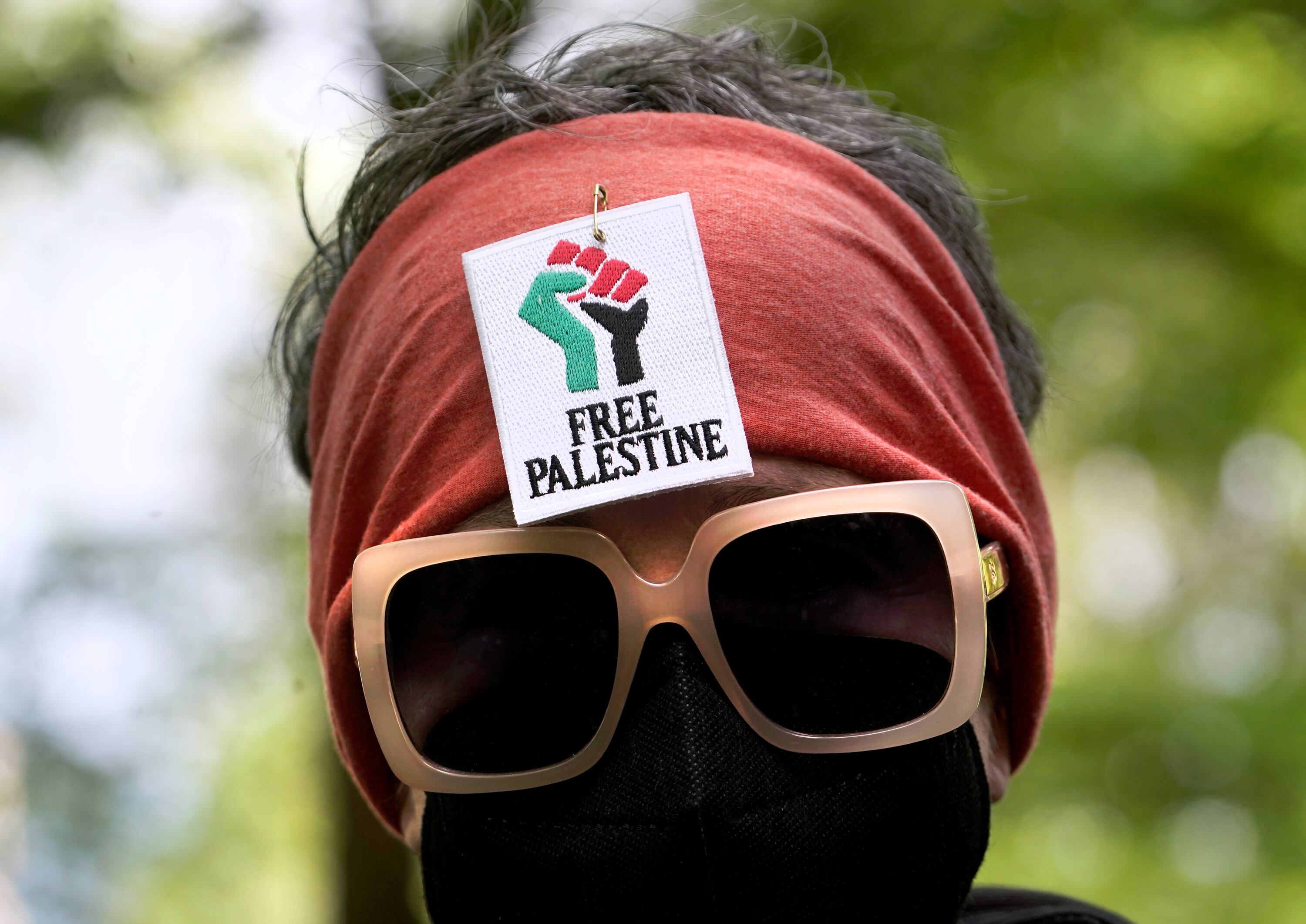 An attendee at a pro-Palestinian protest, with a sign reading 
