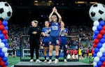 OL Reign forward Megan Rapinoe acknowledges the crowd as coach Laura Harvey (from left), defender Lauren Barnes, and midfielder Jess Fishlock stand nearby during a ceremony honoring her career, after the team's NWSL soccer match against the Washington Spirit on Friday.