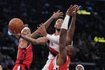 Portland Trail Blazers guard Anfernee Simons, center, shoots as Los Angeles Clippers guard Jordan Miller, and guard Kris Dunn defend during the first half of an NBA basketball game, Tuesday, Dec. 3, 2024, in Inglewood, Calif.