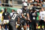 Oregon quarterback Dante Moore (5) hands off to running back Jordon Davison as they warm up before an NCAA college football game against Oregon State, Saturday, Sept. 20, 2025, in Eugene, Ore. (AP Photo/Lydia Ely)