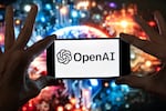 FILE - The OpenAI logo is displayed on a cell phone in front of an image generated by ChatGPT's Dall-E text-to-image model, Dec. 8, 2023, in Boston.