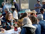 Gov. Kate Brown eats pancakes at the Cowboy Breakfast in Pendleton on Sept. 16, 2022. Nearby, Democratic candidate Tina Kotek speaks to voters.