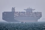 A container ship sits at anchor as a small motorboat passes in the foreground in the Strait of Hormuz off Bandar Abbas, Iran, on May 2.