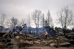 A fire still burns in a home destroyed by the Marshall Wildfire in Louisville, Colo., Friday, Dec. 31, 2021.