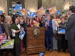 Supporters of Washington’s new income tax on millionaires celebrate as Gov. Bob Ferguson prepares to sign it on Monday, March 30, 2026, in Olympia, Wash.