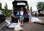 Soren Mattson waits by the car as his parents inflate their floats and paddle board. 