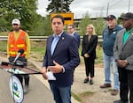 EPA Region 10 Administrator Casey Sixkiller, front, talks to reporters and Bethel-area residents about the efforts to cleanup the J.H. Baxter wood treatment facility across the street. He was joined by, from left to right on the rear, EPA project lead Randy Nattis. Eugene City Councilor Matt Keating, DEQ Director Leah Feldon, Eugene City Councilor Randy Groves and Oregon State Sen. James Manning.