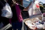 California will require shoppers to use paper bags or a reusable bag. In this photo from 2007, a woman loads plastic bags of groceries into her car at a Safeway store in San Francisco, before the city — and later, the state — adopted a ban on plastic checkout bags.