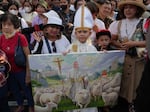 Worshipers hold a painting as they wait for Pope Francis outside the Cathedral of Our Lady of the Assumption, in Jakarta, Indonesia, Wednesday.