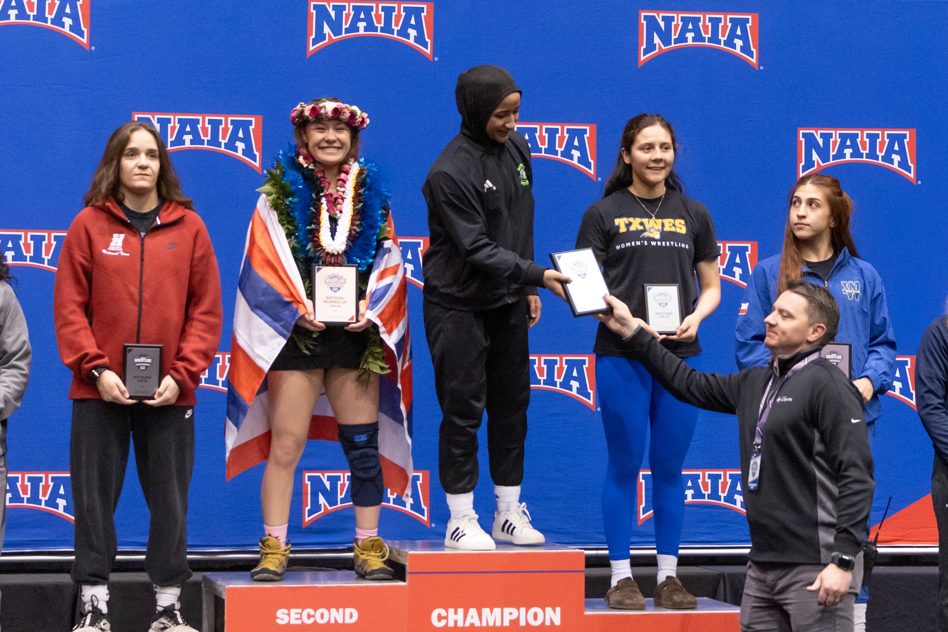 Zaynah McBryde receives her plaque after winning the 2025 championship for her weight class.