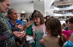 Georgia Krugel is surrounded by fellow skaters and friends after performing at the Lloyd Center ice rink on its final open day. Krugel has been skating at the rink since she was five and is part of a tight-knit community that lobbied to try and save the rink.