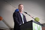 Man standing at a podium gazes into the crowd