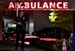 An armed police officer guards the ambulance entrance to the Central Maine Medical Center in Lewiston, Maine, early on Oct. 26, 2023. A massive manhunt was under way for 40-year-old Robert Card, who officials identified as a person of interest.