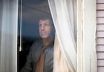 Joe Dibee looks out of a window at his family's home on Wednesday, February 17, 2021, in Seattle.