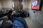 A Palestinian family in Rafah watches the U.N.'s top court on TV on announce its initial decision Friday, Jan. 26, in a case accusing Israel of genocide.