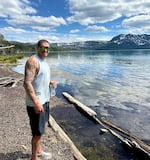 In this photo taken and provided by Kelli Hayes, Paul Akehurst stands by Paulina Lake in Deschutes County after a hike on June 14, 2025.