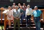 A group of nine people pose for a photo on the back deck of the Wallowa Lake Lodge.