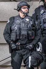 FILE: In this 2020 photo supplied by a protest observer, Portland Police Bureau Officer Corey Budworth is suited up in front of the Multnomah County Justice Center. Budworth was indicted with one count of fourth-degree assault for physically injuring someone during a protest, a charge that was later dropped.