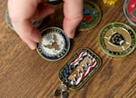 Megan Sholin shows challenge coins that she has collected over the years, April 21, 2025. Sholin is a veteran of the U.S. Navy and received her first challenge coin when she was still in high school, when Associate Director of Naval Intelligence, Rear Adm. Ann Debaets Gilbride, visited Hesperia High.