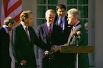 President Clinton shakes hands with Senate Majority Leader-in-waiting Bob Dole of Kansas in the Rose Garden of the White House, Wednesday November 23, 1994, where Dole delivered his support for the General Agreement on Tariffs and Trade(GATT). Sen. Bob Packwood, R-Ore., second from left, and White House Chief of Staff Leon Panetta, second from right, look on.