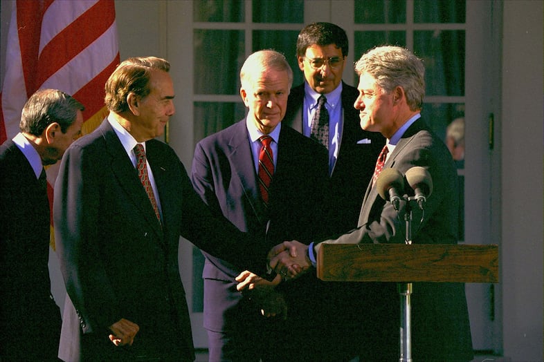 President Clinton shakes hands with Senate Majority Leader-in-waiting Bob Dole of Kansas in the Rose Garden of the White House Wednesday November 23, 1994, where Dole delivered his support for the General Agreement on Tariffs and Trade(GATT). Sen. Bob Packwood, R-Ore., second from left, and White House Chief of Staff Leon Panetta, second from right, look on.